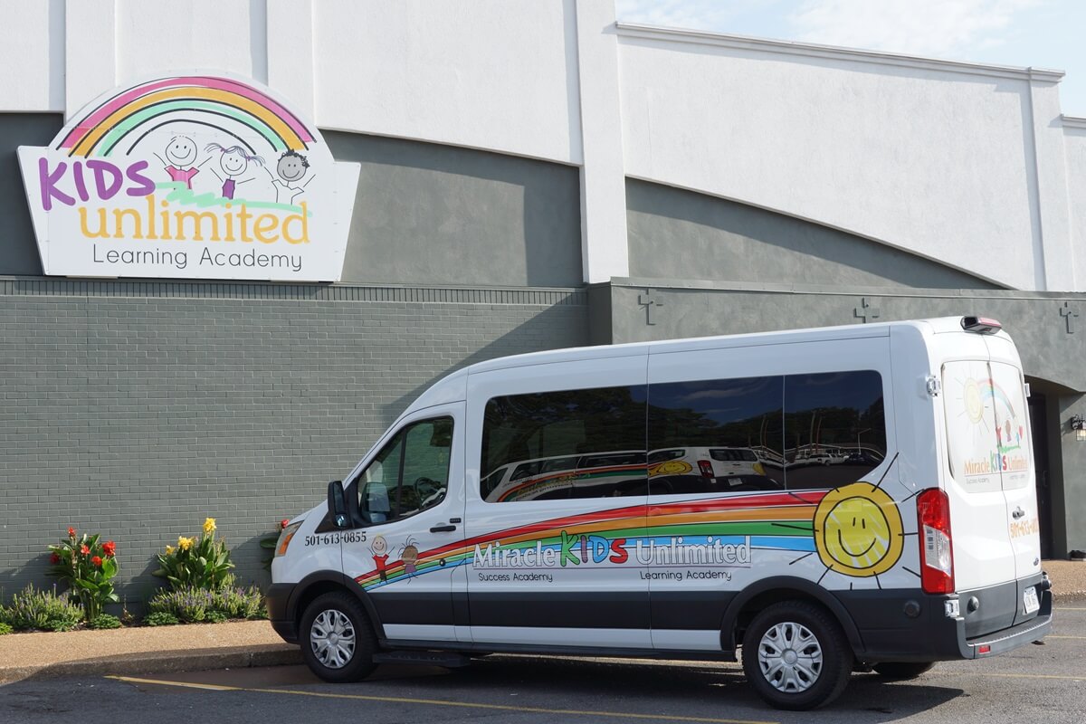 Kids Unlimited van service van parked outside a location